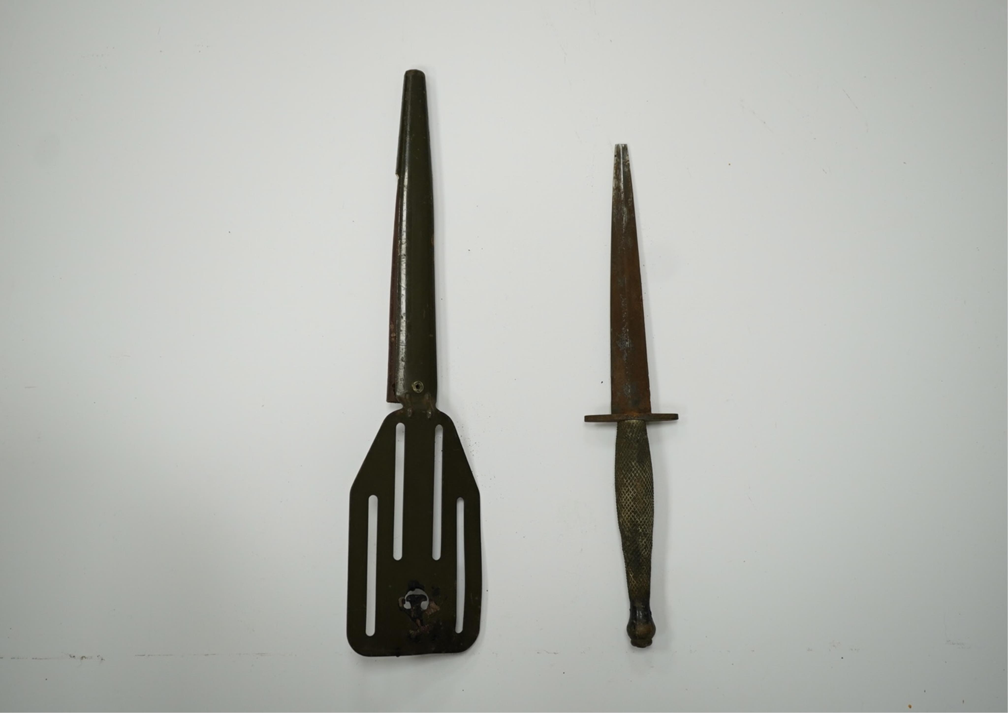 A WW2 US OSS Commando fighting knife (with broken tip), blade 14.5cm, and a spatula sheath. Condition - poor, broken tip and considerable surface rust, etc.